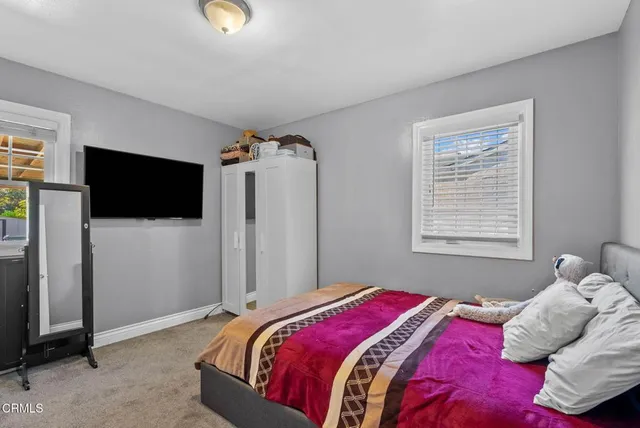 a bedroom with a bed and a flat tv screen