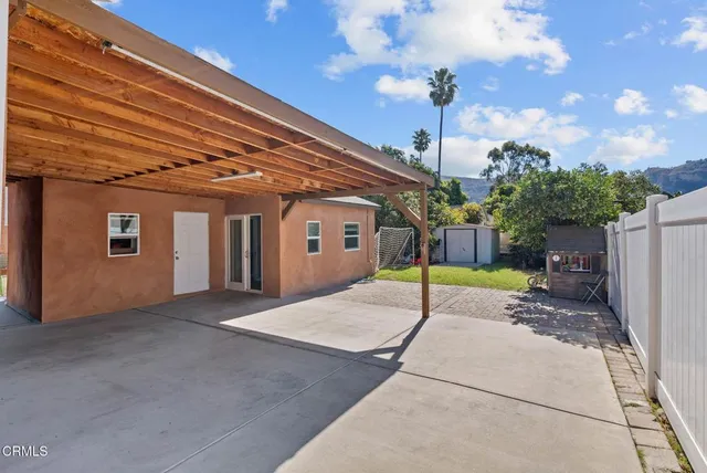 a view of a house with a patio and a yard