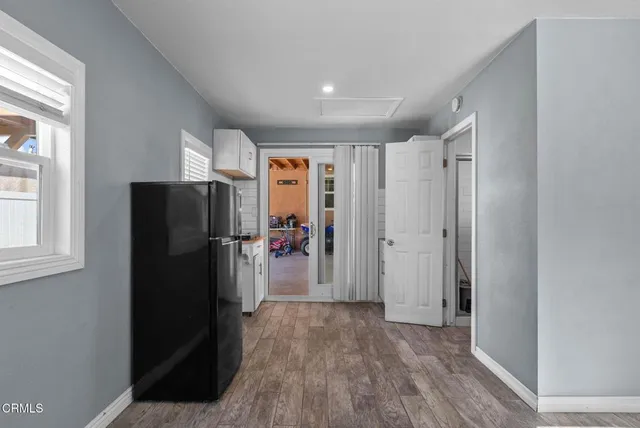a view of a kitchen with refrigerator and wooden floor