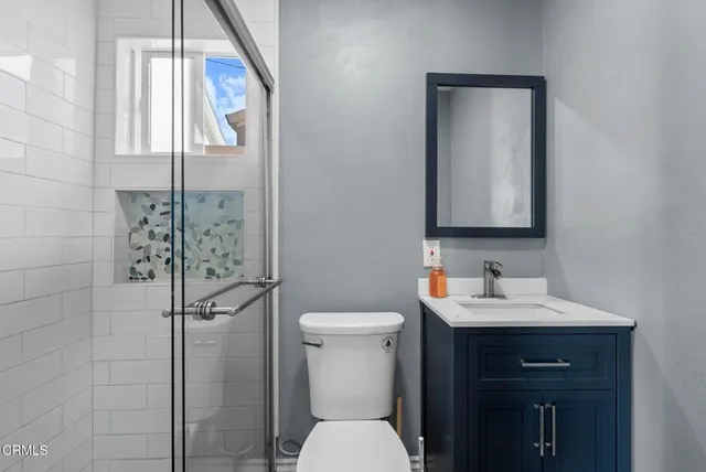 a bathroom with a toilet sink and mirror