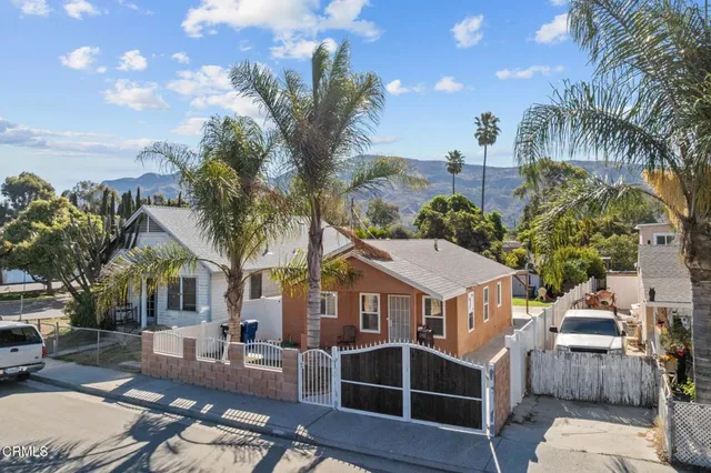 a view of a house with a patio and a yard