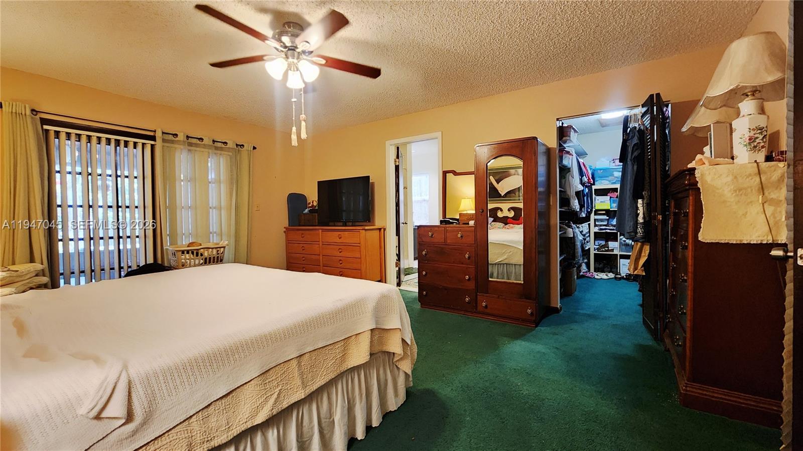 15151 Southwest 166th Street Miami, FL 33187 - Photo 11 of 37 a bedroom with a bed closet and flat tv screen