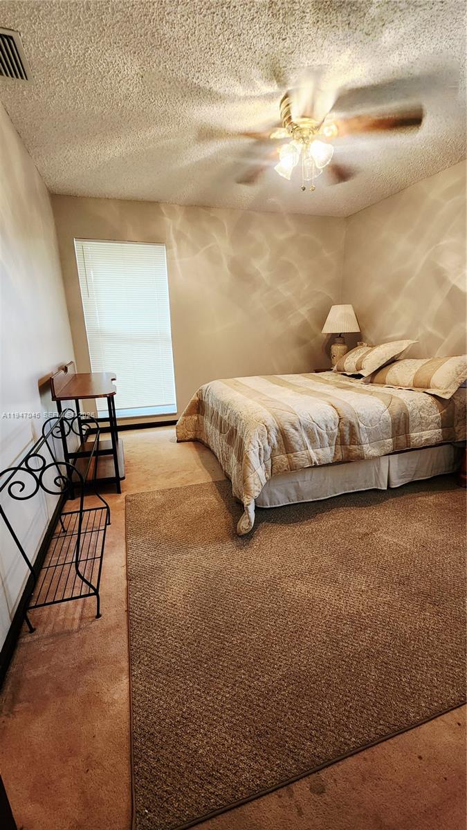 15151 Southwest 166th Street Miami, FL 33187 - Photo 19 of 37 a spacious bedroom with a bed and chair