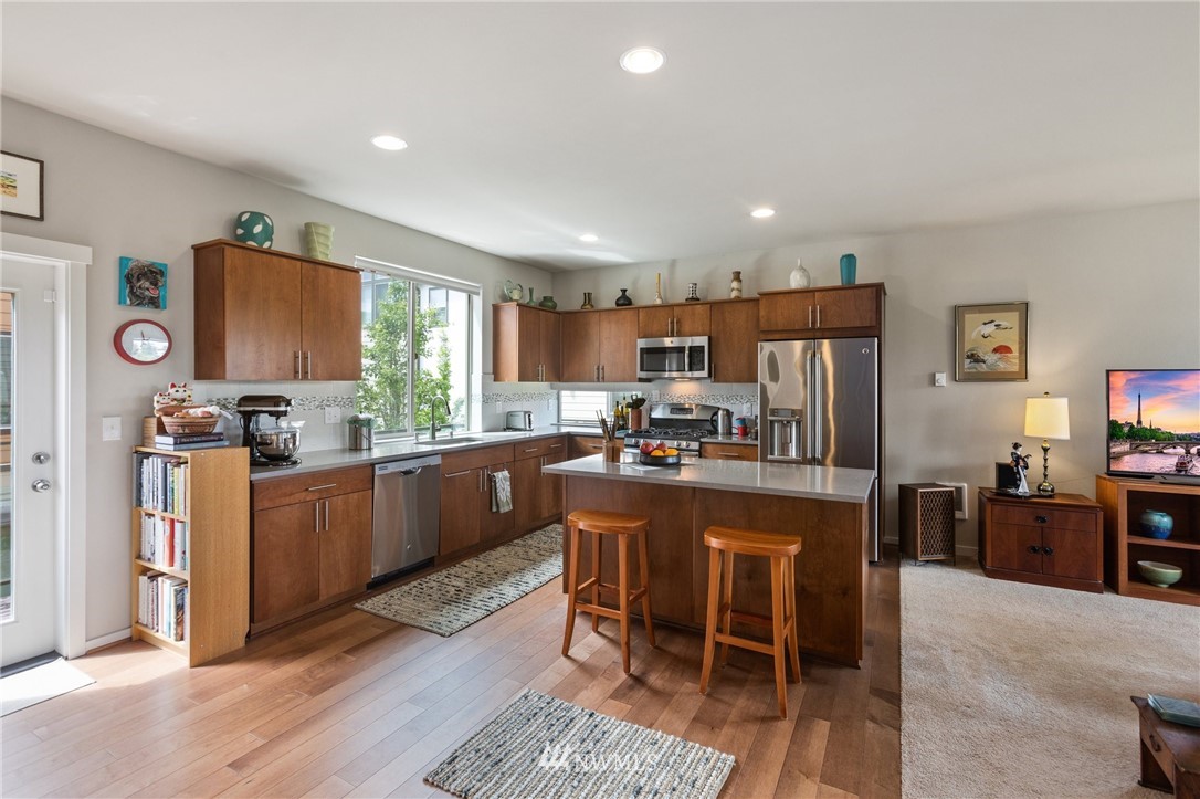 4514 Northeast 3rd Lane Renton, WA 98059 - Photo 6 of 22 a kitchen with kitchen island granite countertop wooden cabinets and stainless steel appliances