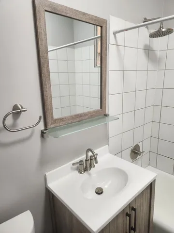 a bathroom with a toilet a sink and mirror