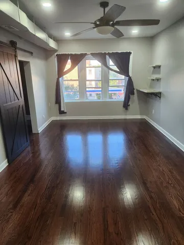 a view of a hallway with wooden floor and a window
