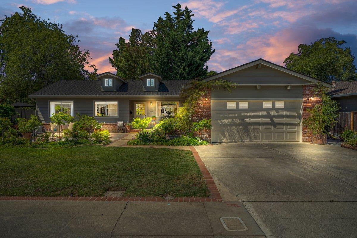 a front view of a house with a yard and potted plants