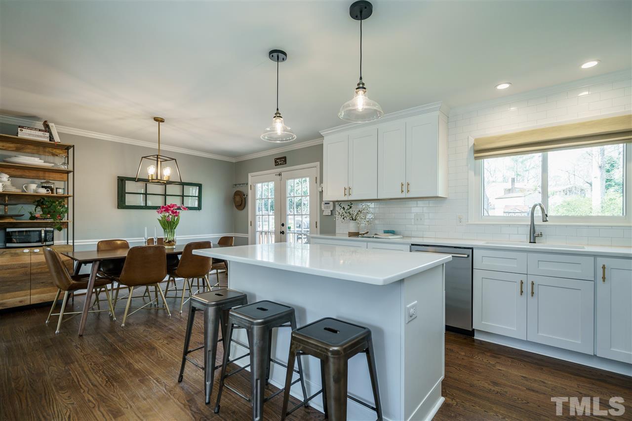 419 East Rowan Street Raleigh, NC 27609 - Photo 8 of 30 a kitchen with stainless steel appliances granite countertop white cabinets and wooden floor