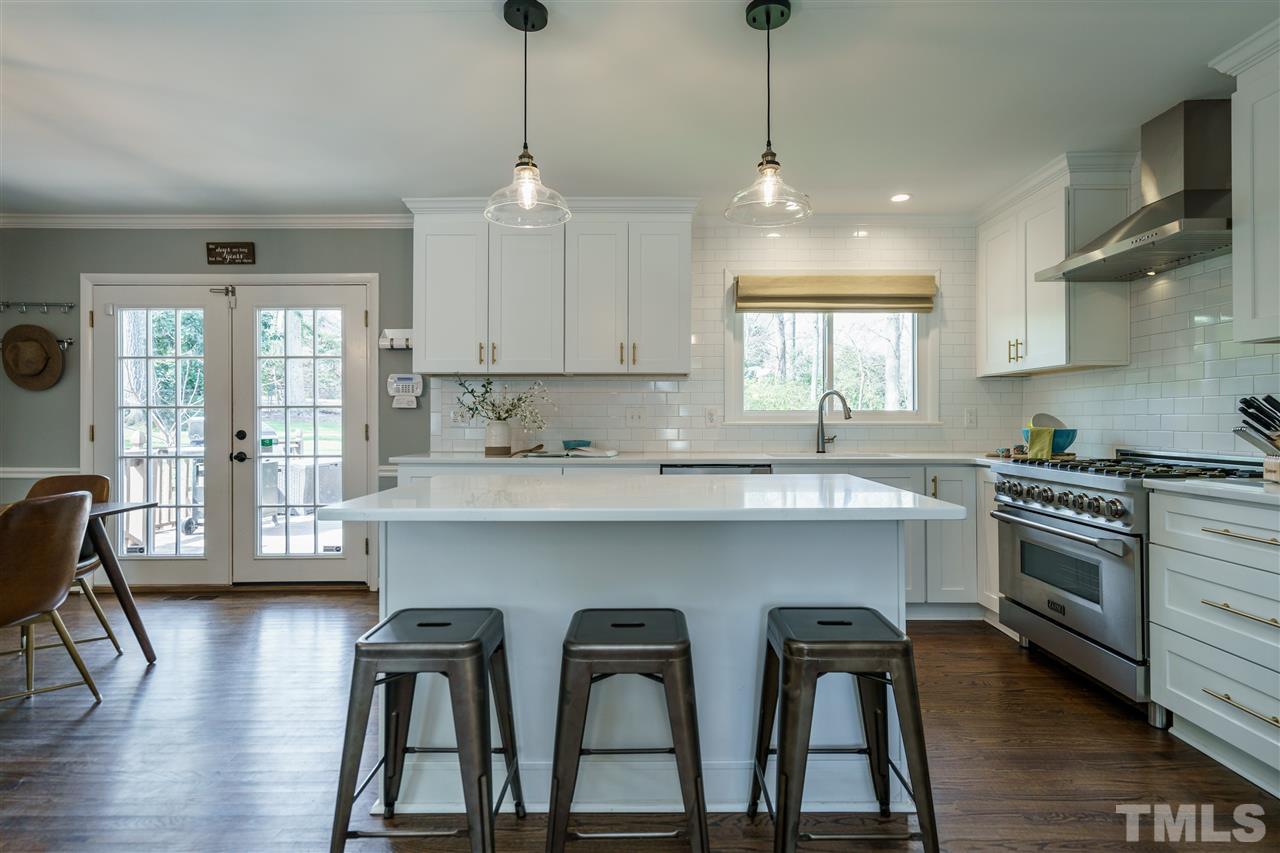 419 East Rowan Street Raleigh, NC 27609 - Photo 9 of 30 a kitchen with stainless steel appliances granite countertop a stove a sink and a wooden cabinets