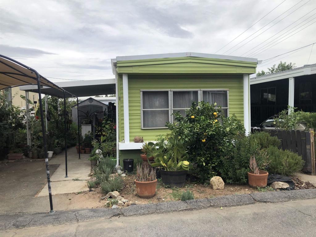 145 East Aviation Road, Unit 22 Fallbrook, CA 92028 - Photo 2 of 7 a view of a house with potted plants and a bench