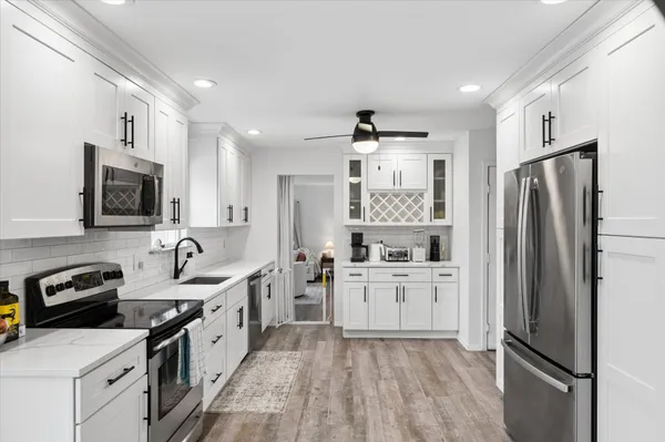 a kitchen with white cabinets and stainless steel appliances