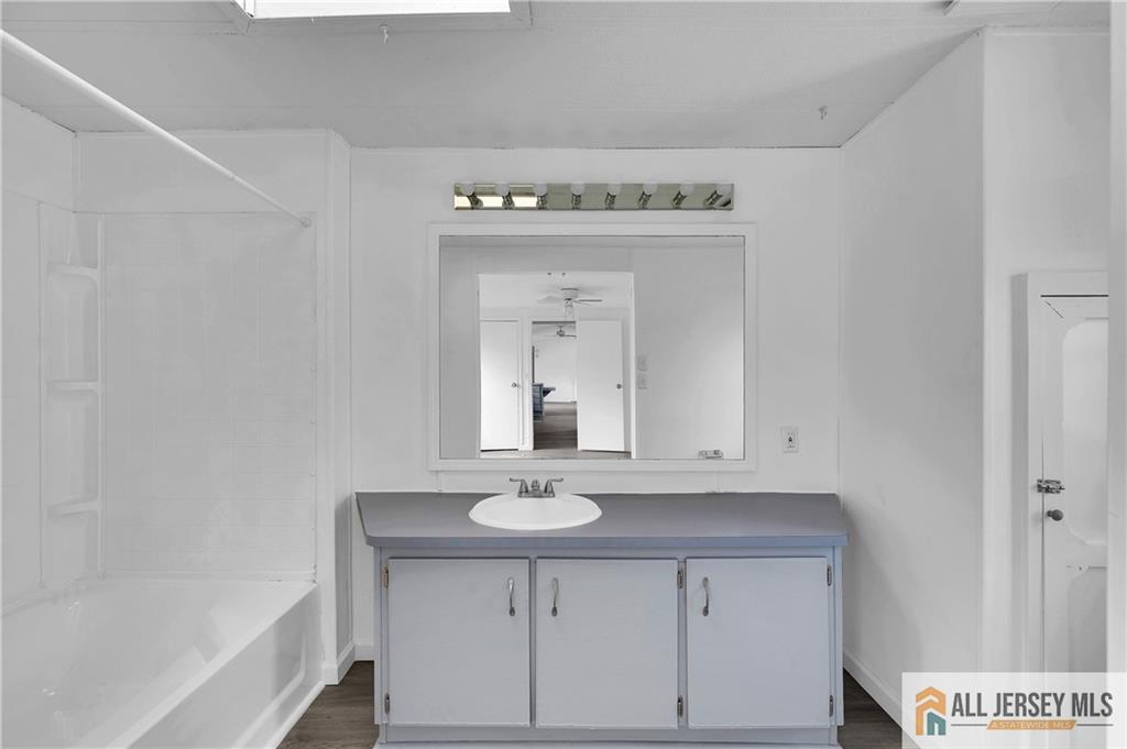 38 Longfellow Road North Brunswick, NJ 08902 - Photo 13 of 23 a bathroom with a sink a vanity and a mirror