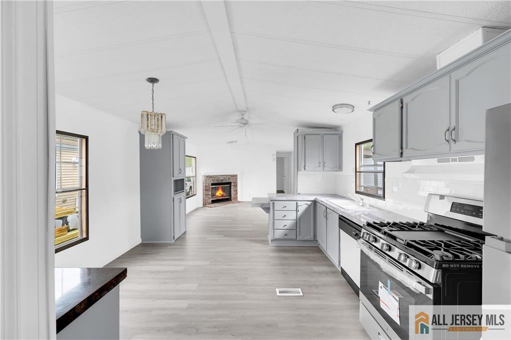 38 Longfellow Road North Brunswick, NJ 08902 - Photo 3 of 23 a kitchen with stainless steel appliances a stove a sink dishwasher a refrigerator white cabinets and wooden floor