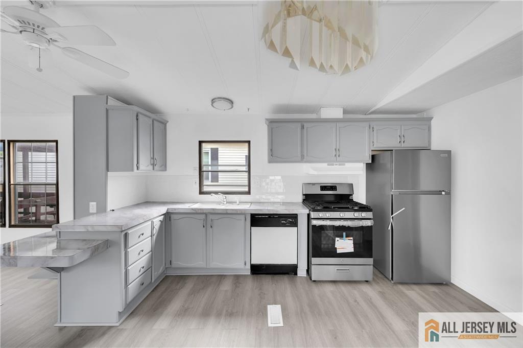 38 Longfellow Road North Brunswick, NJ 08902 - Photo 4 of 23 a kitchen with stainless steel appliances a stove a sink and white cabinets