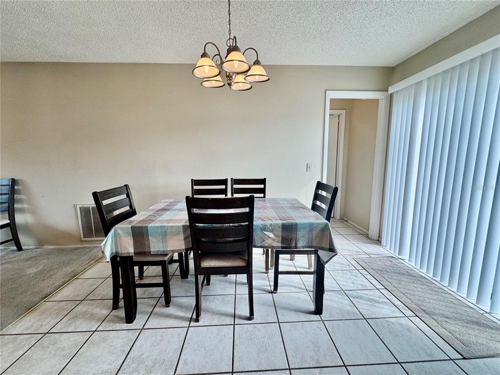 13188 Delbarton Street Spring Hill, FL 34609 - Photo 6 of 23 a view of a dining room with furniture and chandelier