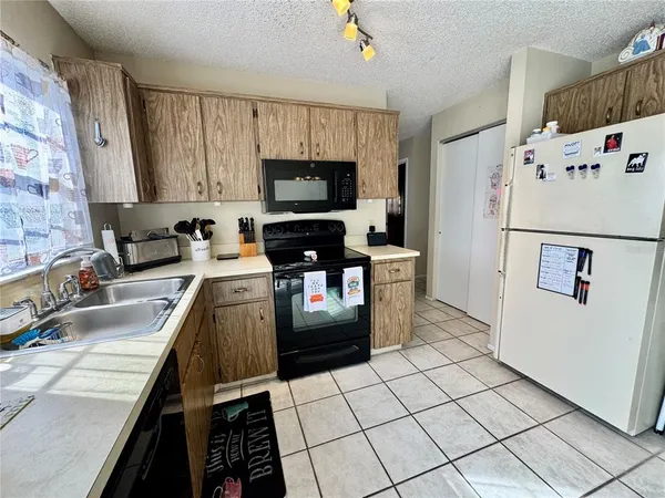 a kitchen with a sink a stove top oven a washer dryer and a dining table