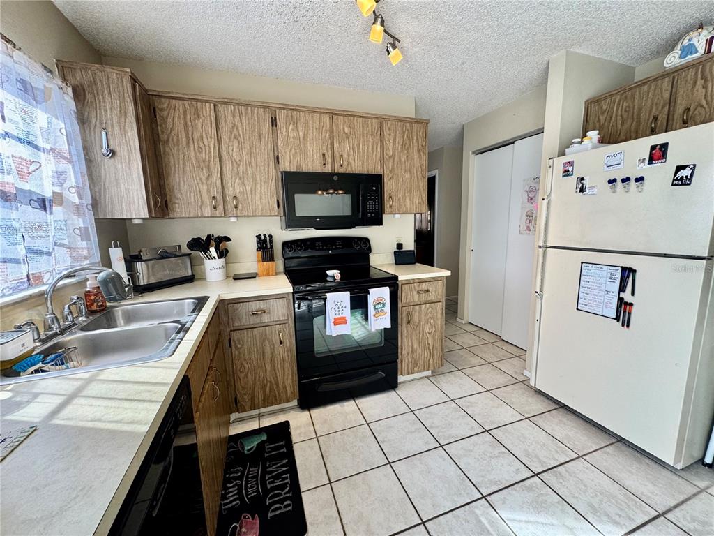 13188 Delbarton Street Spring Hill, FL 34609 - Photo 9 of 23 a kitchen with granite countertop a refrigerator sink and stove