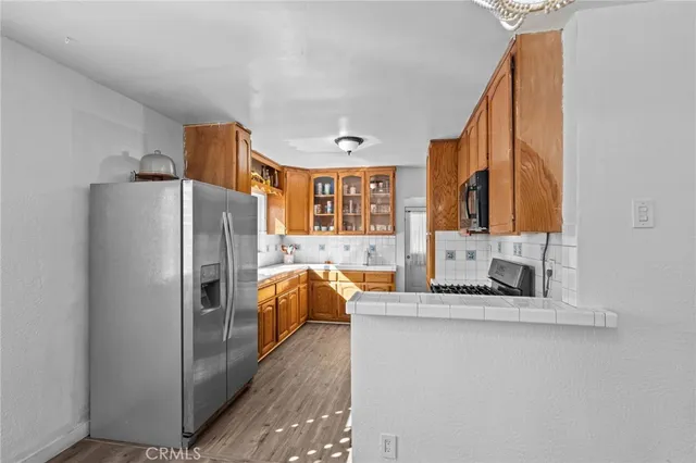 a kitchen with stainless steel appliances granite countertop a refrigerator and a sink