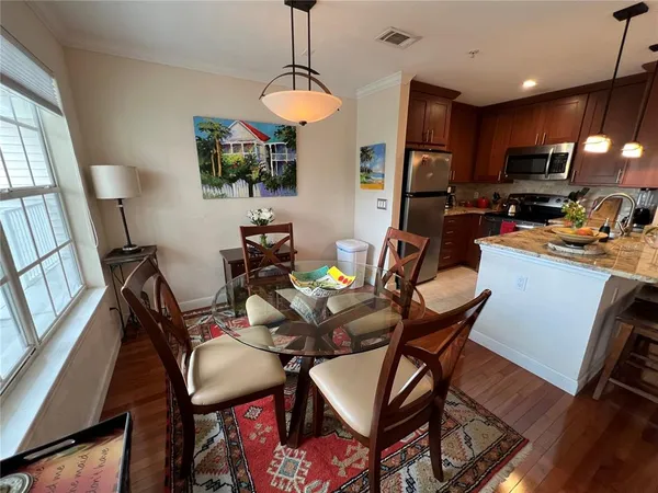 a dining room filled chandelier and wooden floor