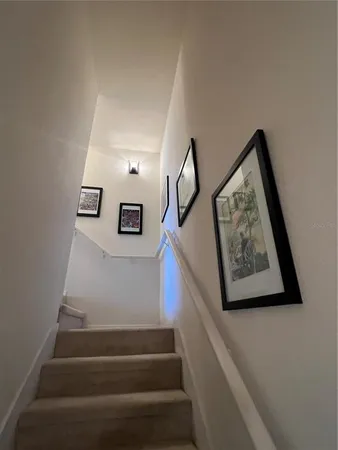 a view of staircase with lots of frames on wall