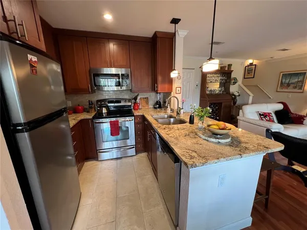 a kitchen with kitchen island granite countertop a sink stove and refrigerator