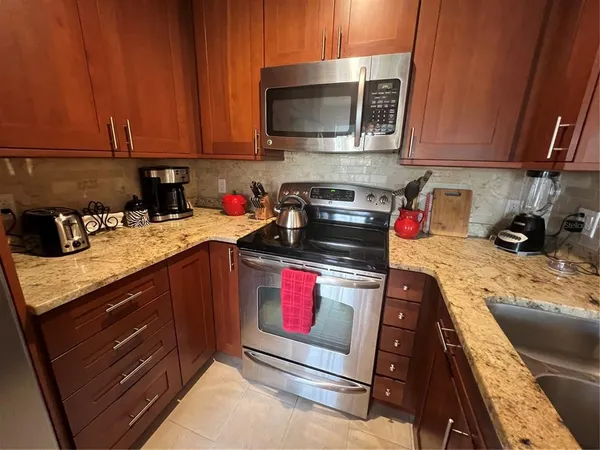 a kitchen with stainless steel appliances granite countertop a stove and a microwave