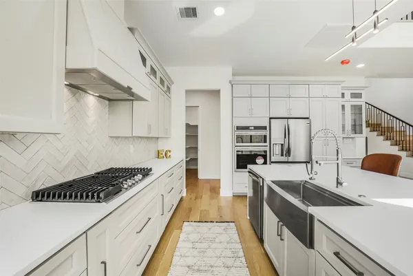 a kitchen with kitchen island a sink stove and cabinets
