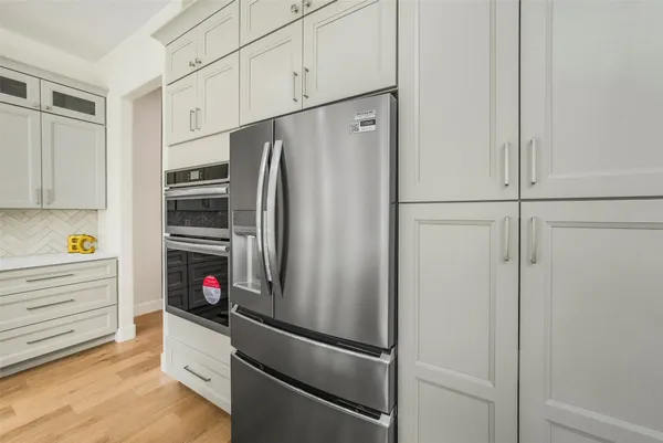 a kitchen with a dining table chairs and sink