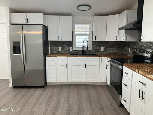 a kitchen with a refrigerator sink and cabinets