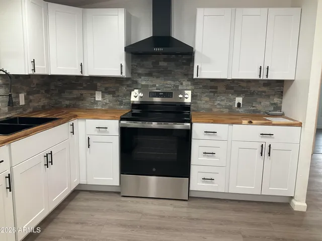 a kitchen with white cabinets and black appliances