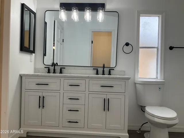 a bathroom with a toilet sink and mirror