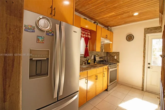 a kitchen with stainless steel appliances granite countertop a refrigerator and a stove