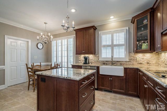 a kitchen with a stove a sink a dining table and chairs