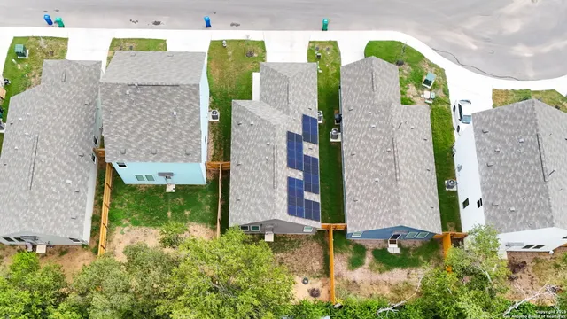 a aerial view of a house with table and chairs under an umbrella