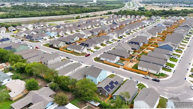 an aerial view of a residential houses with yard
