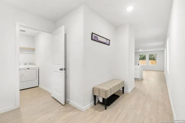 a view of a hallway with entryway and wooden floor