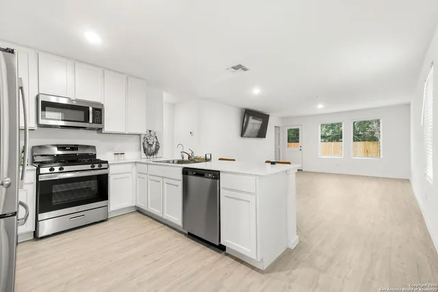 a kitchen with stainless steel appliances kitchen island granite countertop a stove a sink and a microwave