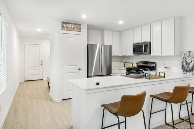 a kitchen with stainless steel appliances a refrigerator and a stove top oven