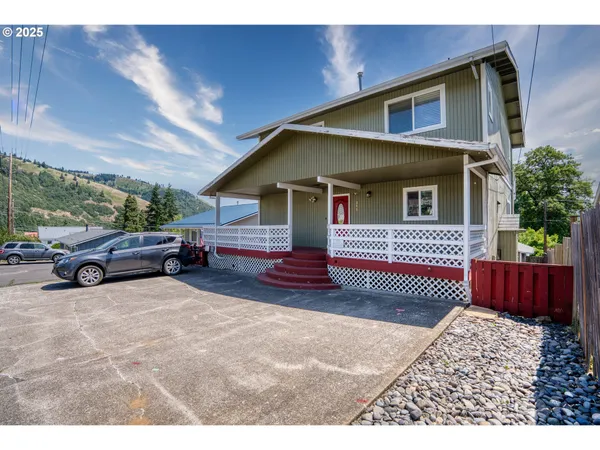 a view of a house with a patio and a yard