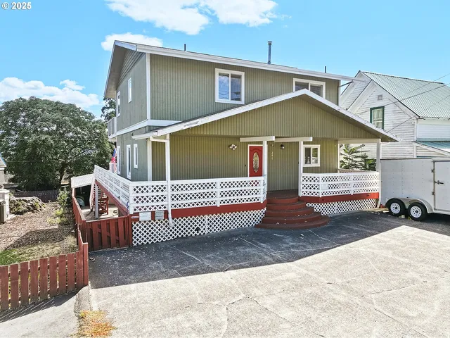 a view of a house with wooden deck and furniture