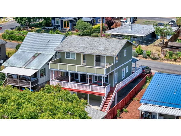 a aerial view of a house with balcony and trees al around
