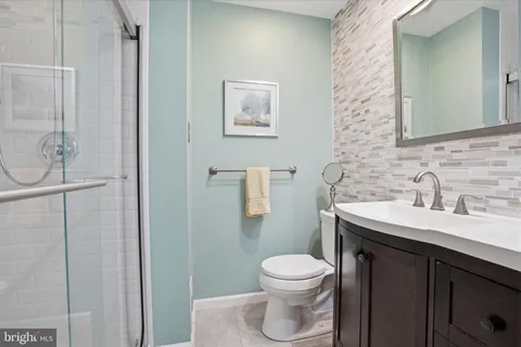 a bathroom with a toilet sink vanity and mirror