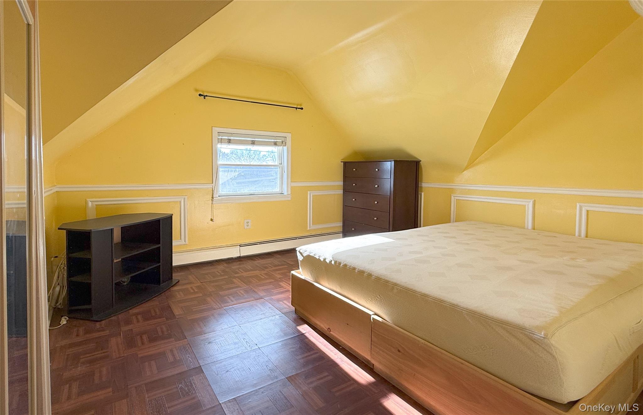 134-37 58th Road Queens, NY 11355 - Photo 17 of 24 Bedroom featuring a baseboard radiator and lofted ceiling