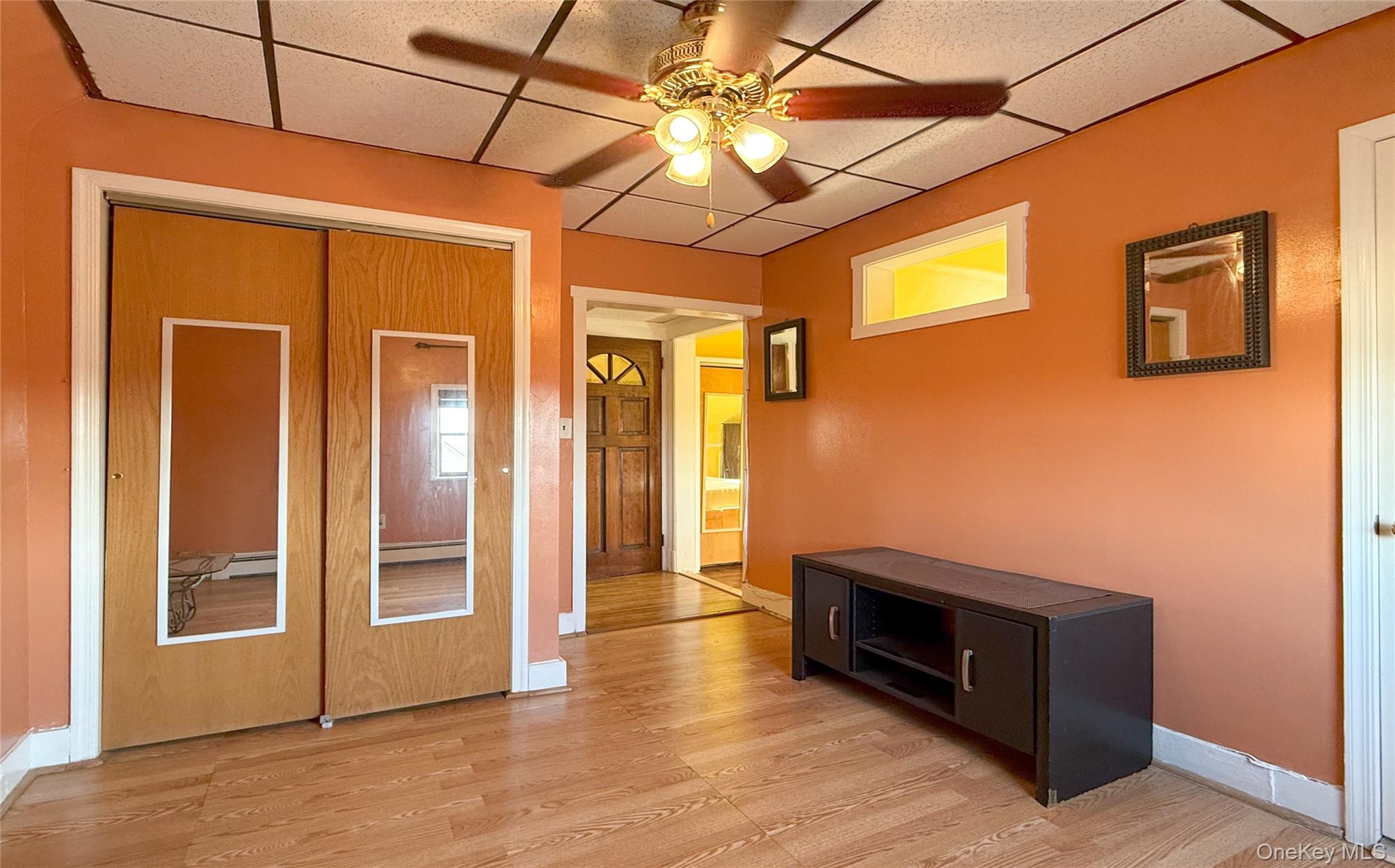 134-37 58th Road Queens, NY 11355 - Photo 20 of 24 Hallway featuring light wood-style floors, a drop ceiling, and a baseboard radiator