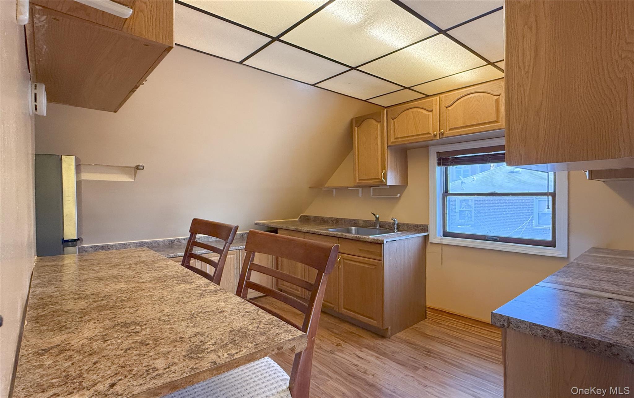 134-37 58th Road Queens, NY 11355 - Photo 22 of 24 Kitchen with stainless steel refrigerator, light wood finished floors, light brown cabinets, and dark countertops