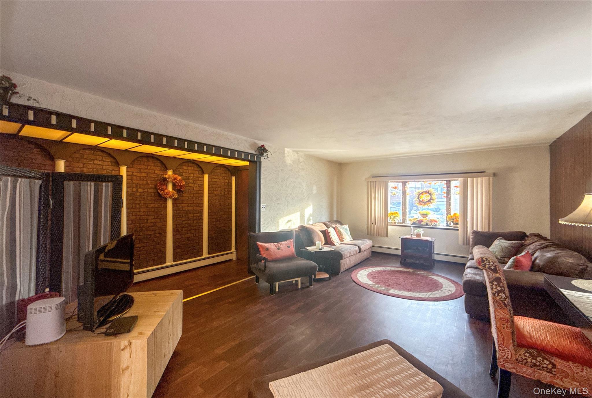 134-37 58th Road Queens, NY 11355 - Photo 24 of 49 Living room with wood finished floors and baseboard heating