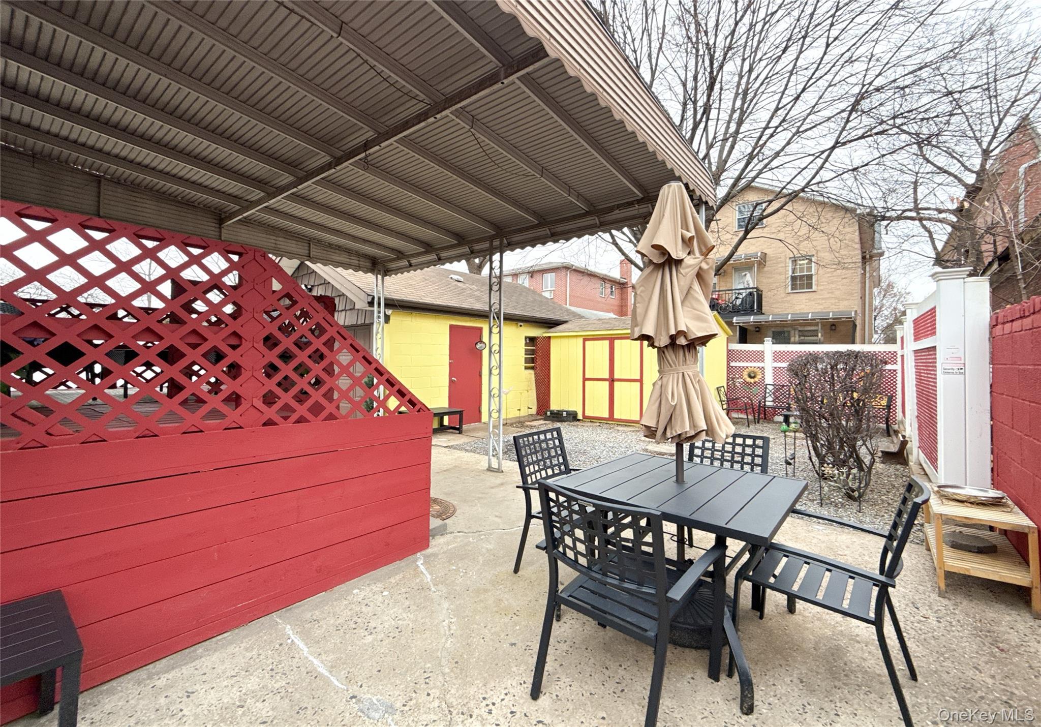 134-37 58th Road Queens, NY 11355 - Photo 10 of 24 Fenced backyard featuring outdoor dining space, a storage unit, and a patio area