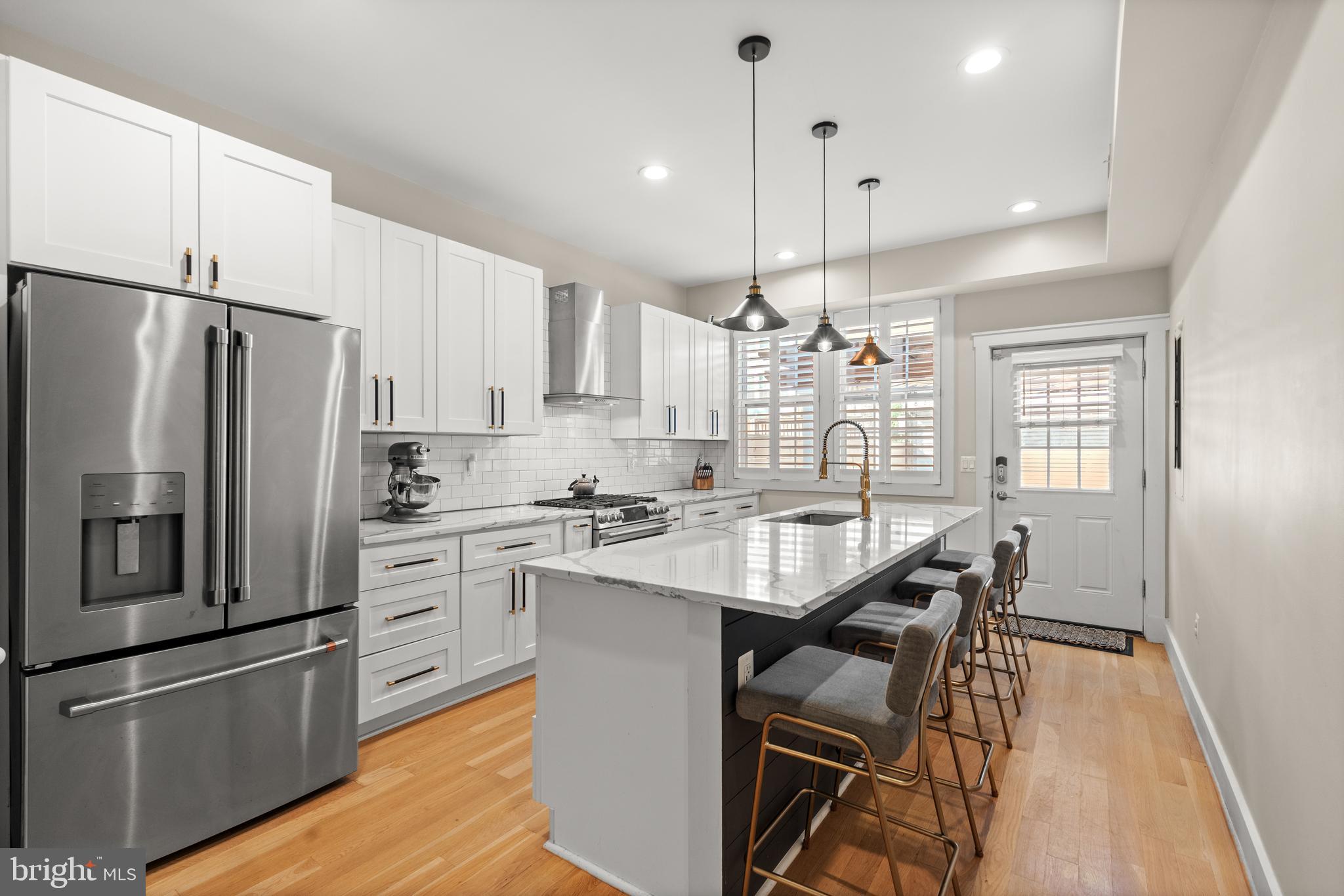 4718 15th Street Northwest Washington, DC 20011 - Photo 12 of 49 a kitchen with stainless steel appliances granite countertop a refrigerator a sink dishwasher a stove a dining table and chairs with wooden floor