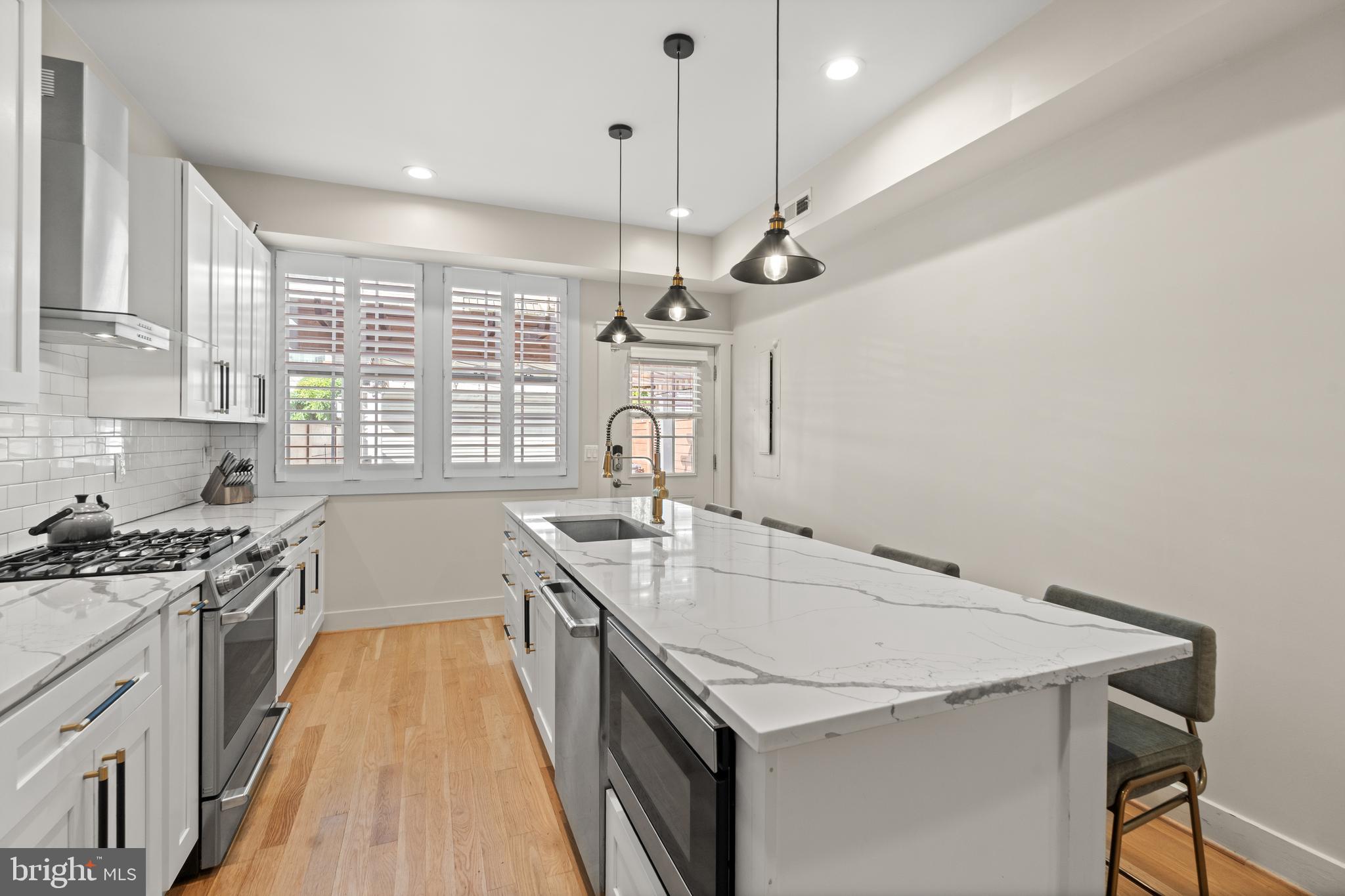 4718 15th Street Northwest Washington, DC 20011 - Photo 16 of 49 a kitchen with a stove a sink a window and chairs