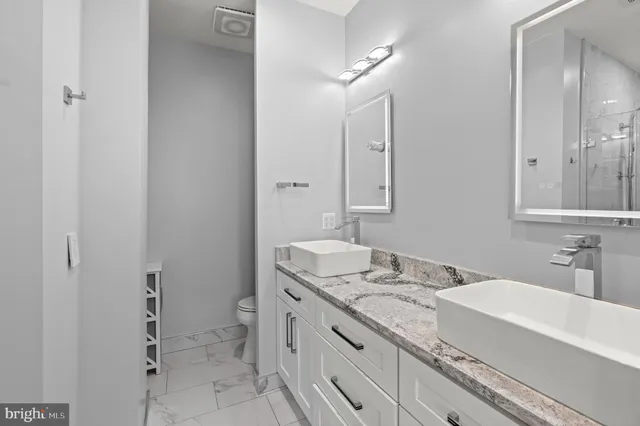 a bathroom with a granite countertop sink toilet and shower